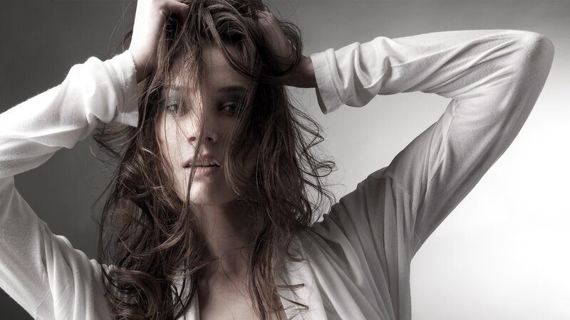 woman with messy hair in white shirt