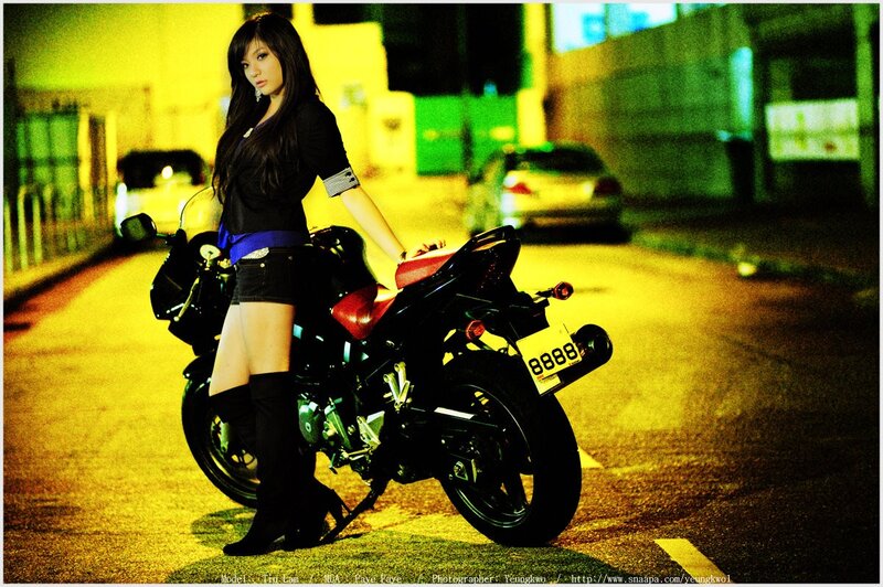 Woman with motorcycle at night