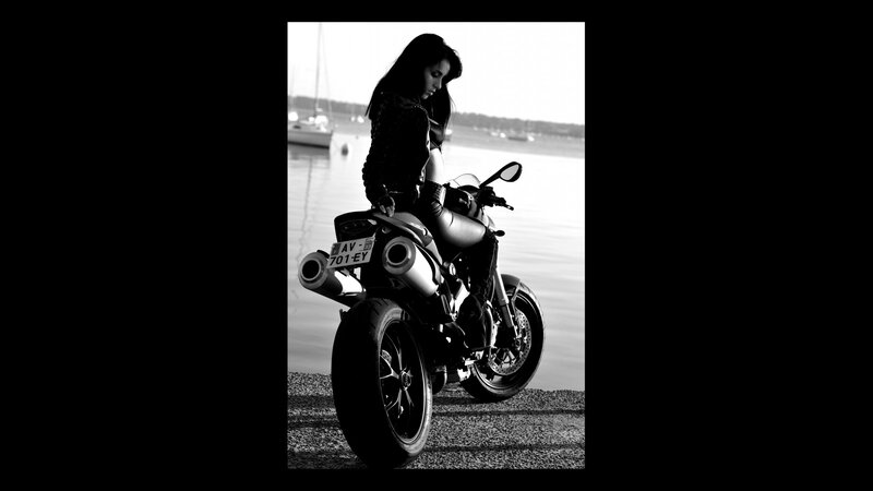 woman with motorcycle by water