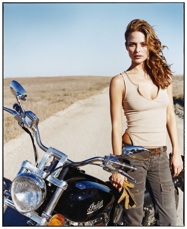 Woman with motorcycle in desert