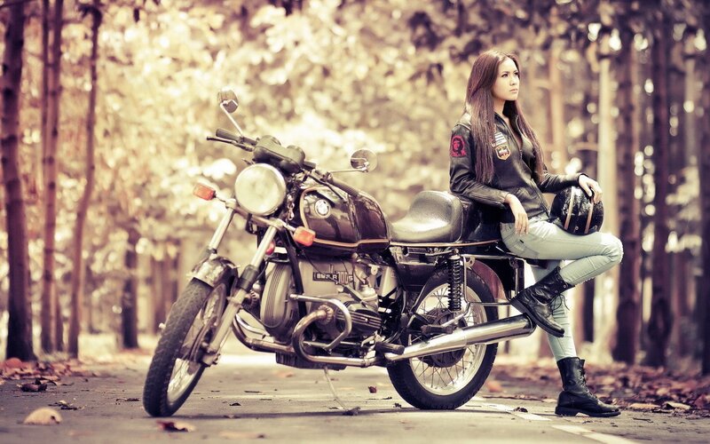 Woman with motorcycle in forest