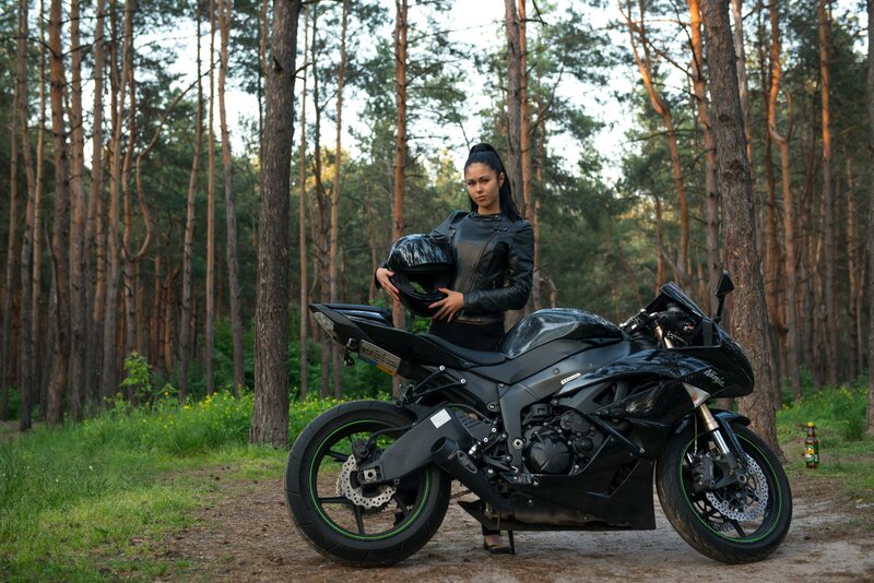 Woman with motorcycle in forest