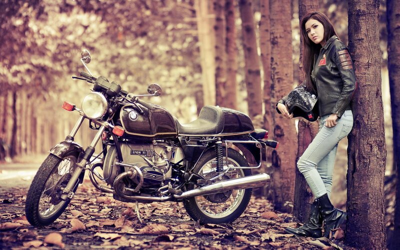 Woman with motorcycle in forest