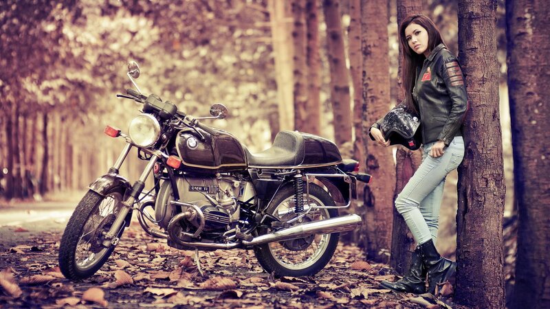 Woman with motorcycle in forest