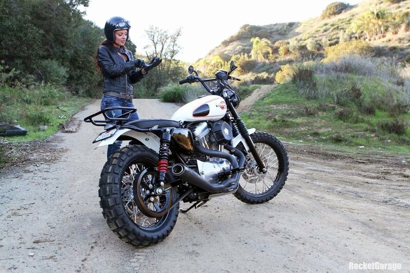 Woman with motorcycle on dirt road