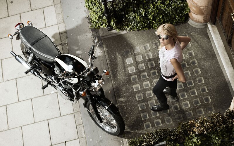 woman with motorcycle on sidewalk