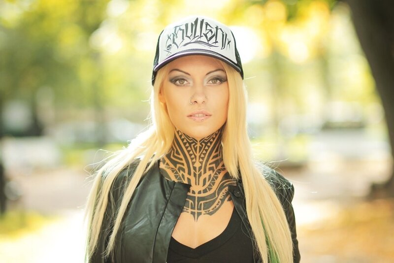 woman with neck tattoo and cap