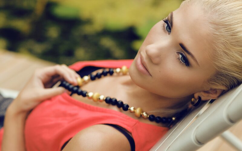 woman with necklace on lounge chair