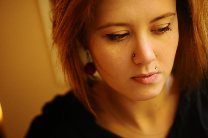 woman with nose piercings looking down