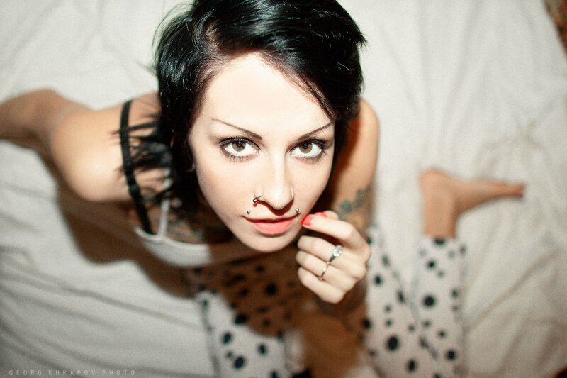 woman with nose piercings lying on bed