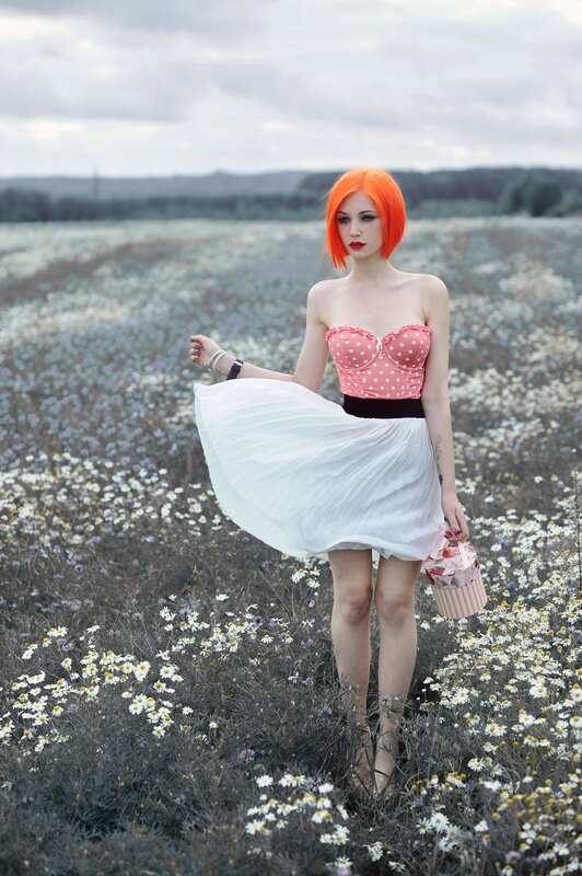 Woman with orange hair in a flower field