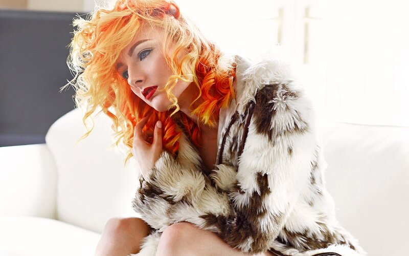 woman with orange hair in fur coat