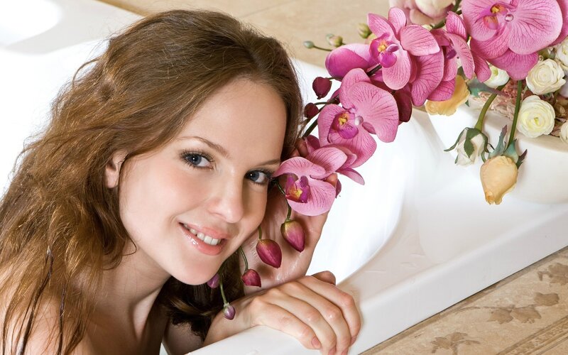 woman with orchids by bathtub