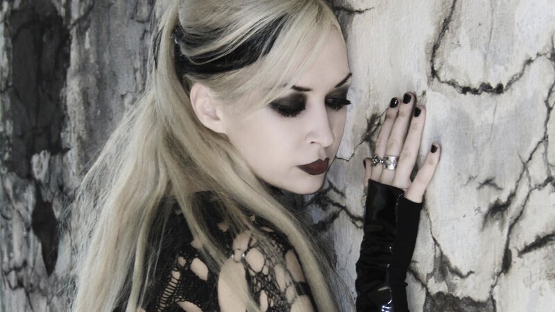 woman with pale makeup and black nails