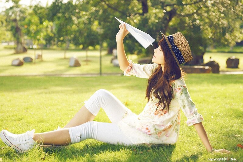 Woman with paper airplane in park