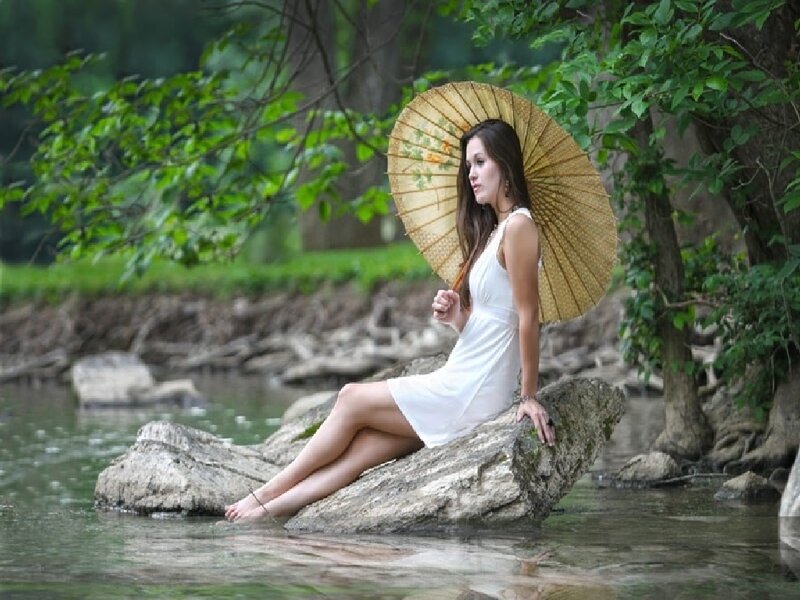 Woman with parasol by river
