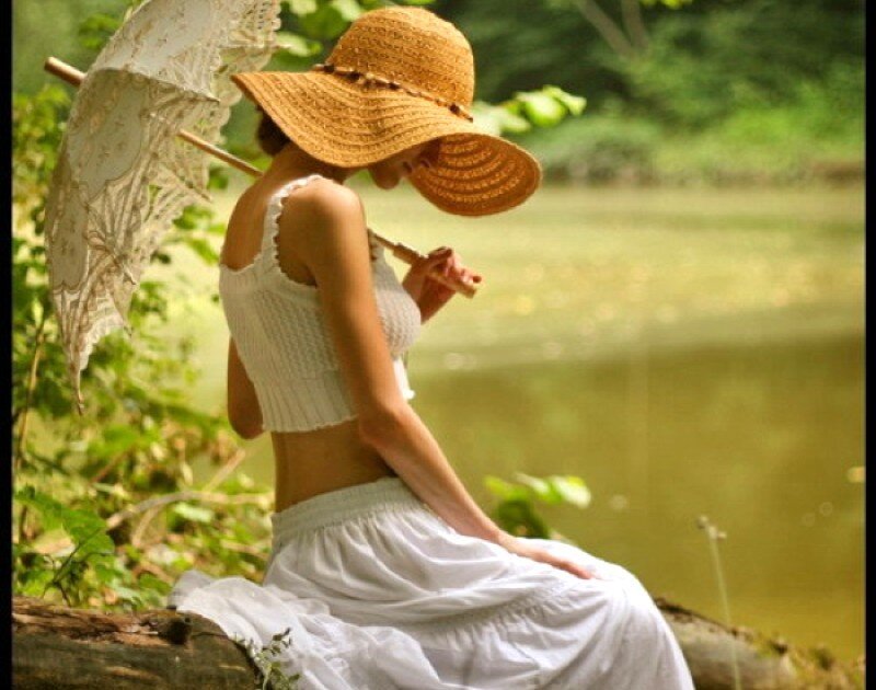 Woman with parasol by the water