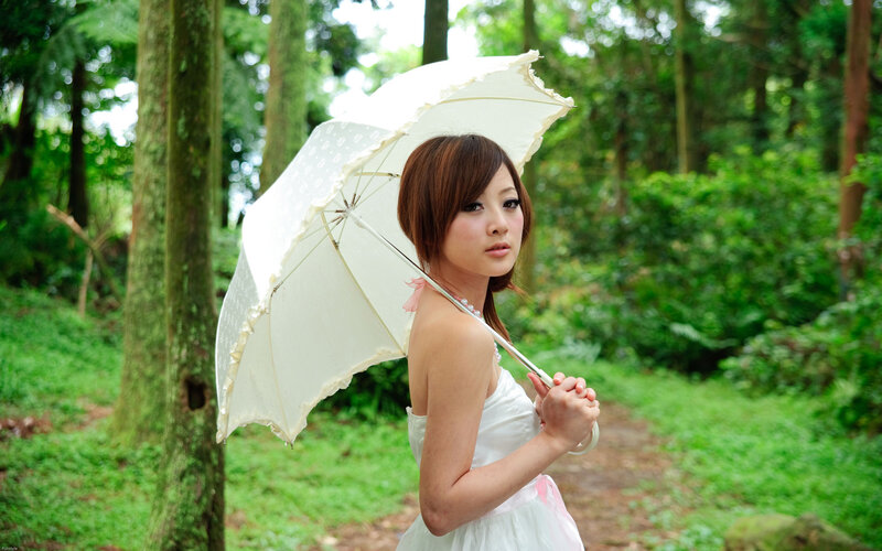 Woman with parasol in forest