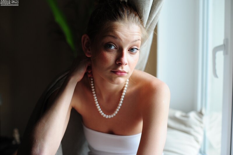 woman with pearl necklace by window
