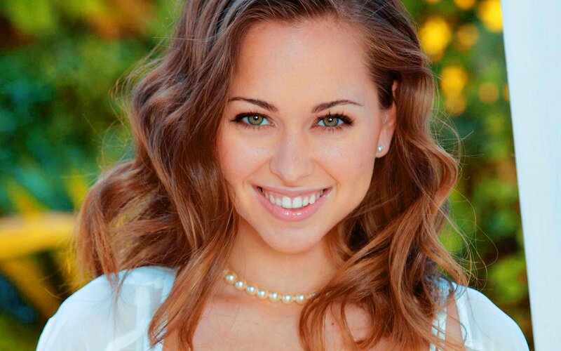 woman with pearl necklace smiling
