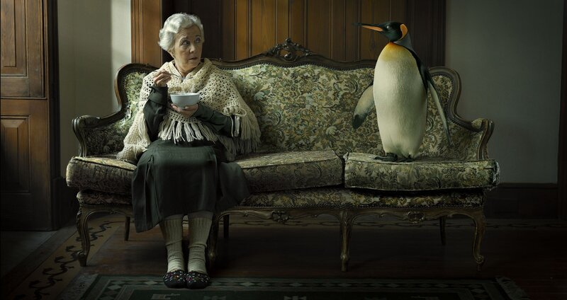 Woman with penguin on couch