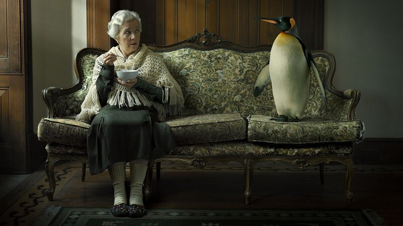 Woman with penguin on couch