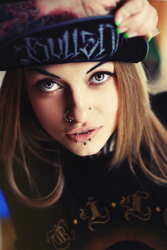 woman with piercings and cap