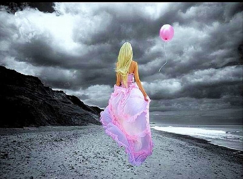 Woman with pink balloon on beach