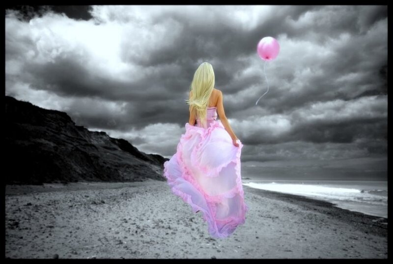 woman with pink balloon on beach