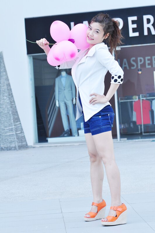 Woman with pink balloons outside store