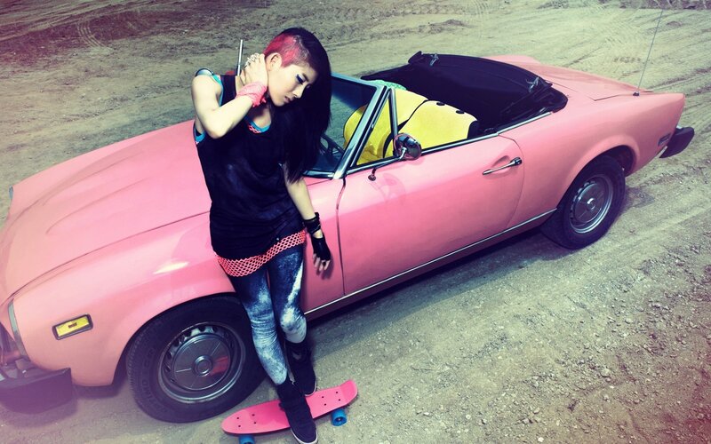 woman with pink car and skateboard