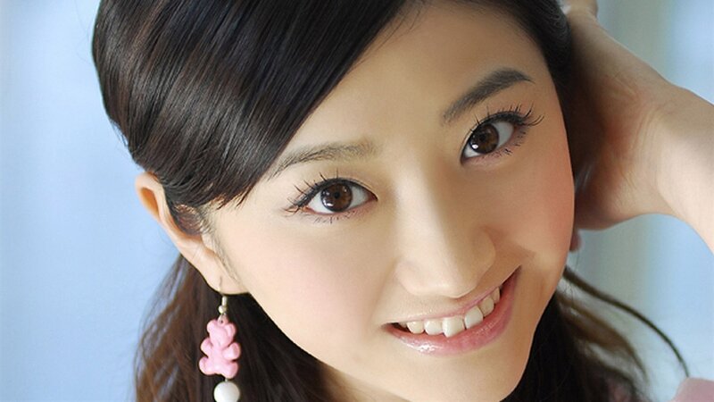 woman with pink earring smiling