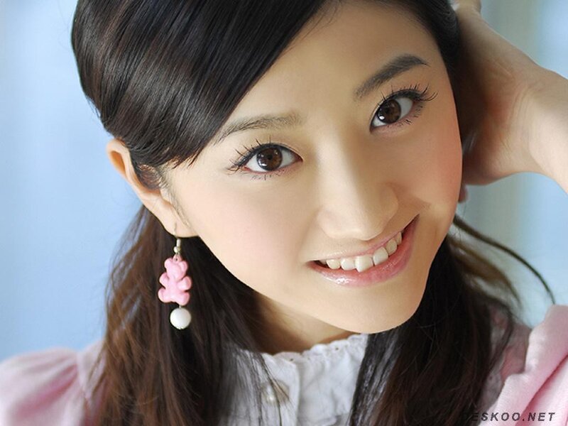 woman with pink earrings smiling