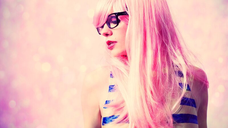 woman with pink hair and glasses