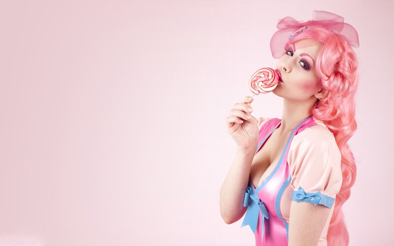 woman with pink hair eating lollipop
