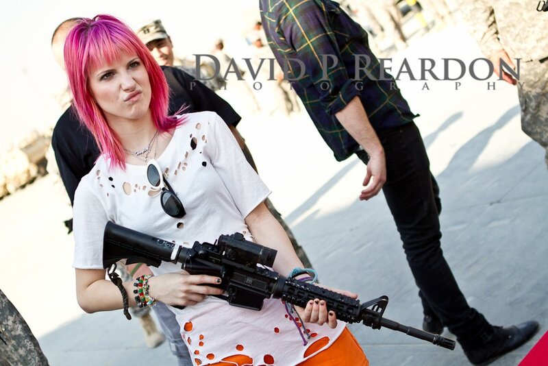 Woman with pink hair holding rifle