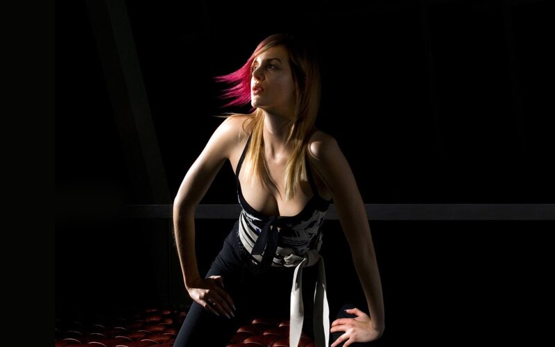 woman with pink hair in dark room