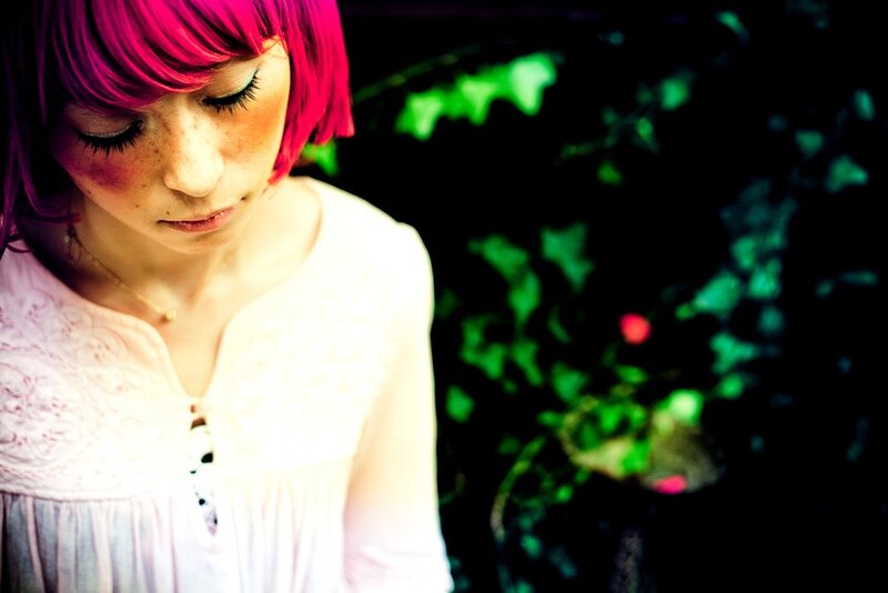 woman with pink hair looking down