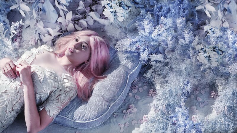 woman with pink hair lying on flowers