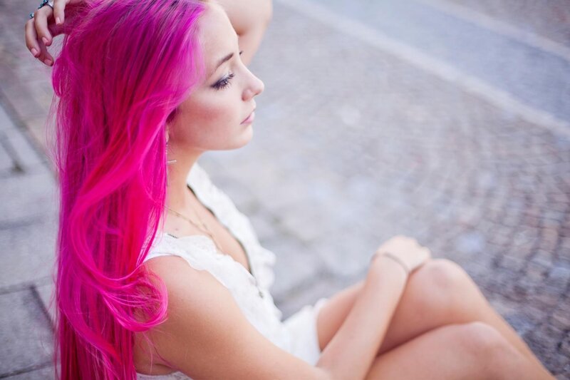 woman with pink hair sitting