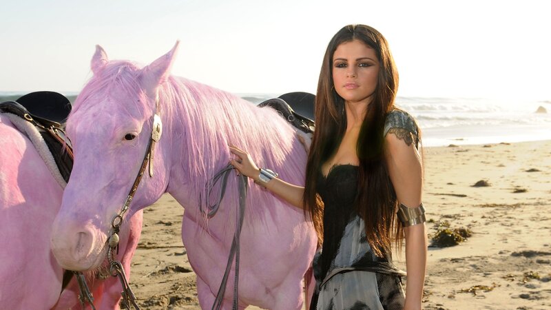 woman with pink horse on beach