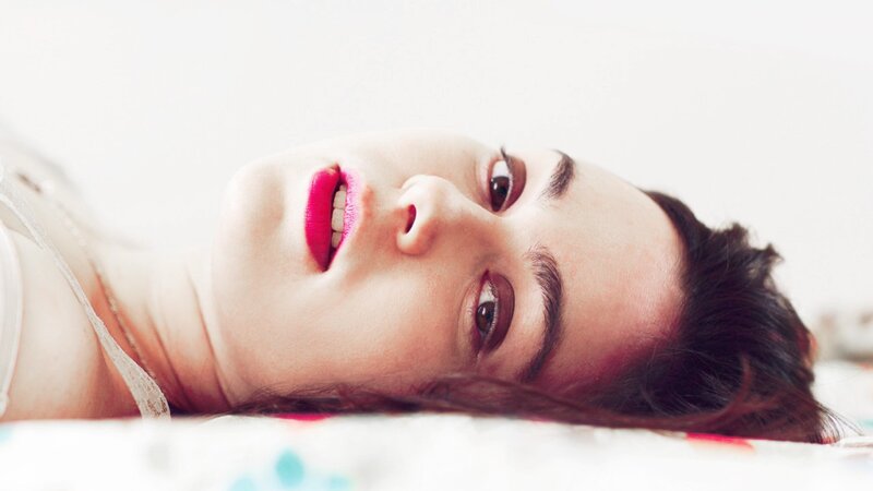 woman with pink lipstick lying down