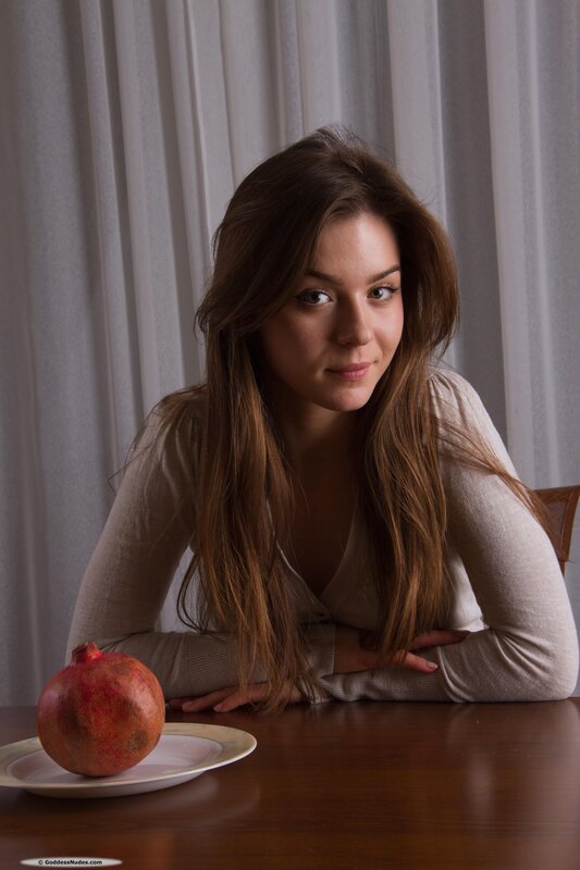 woman with pomegranate on table