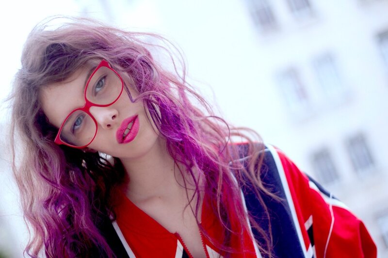 woman with purple hair and red glasses