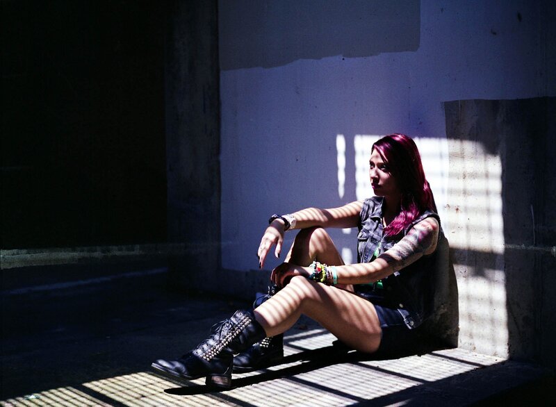 woman with purple hair sitting in sunlight