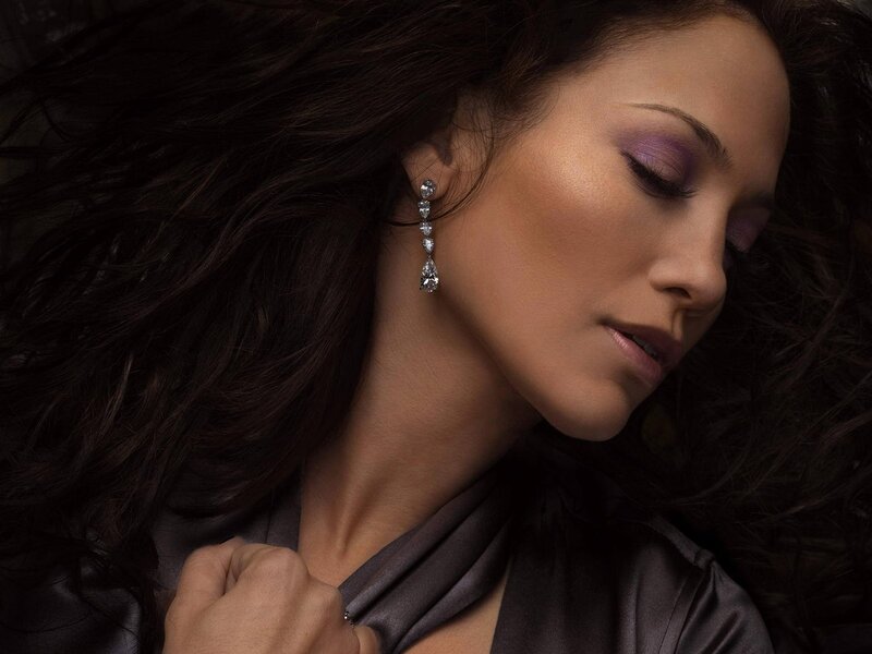 woman with purple makeup and earrings