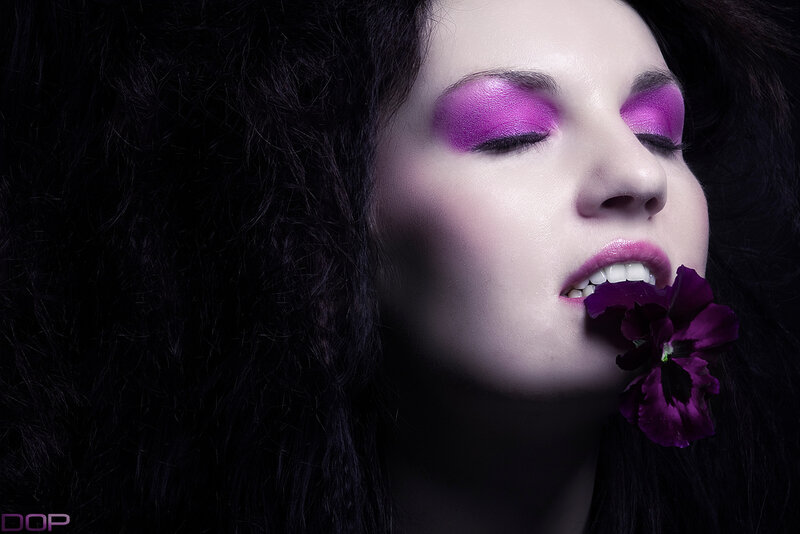 woman with purple makeup and flower