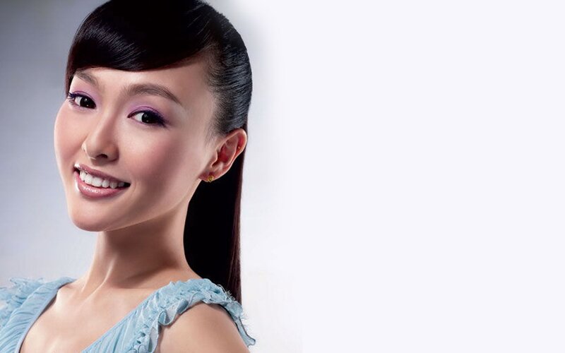 woman with purple makeup smiling