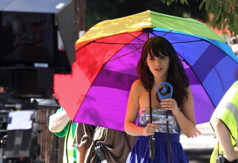 Woman with rainbow umbrella on set