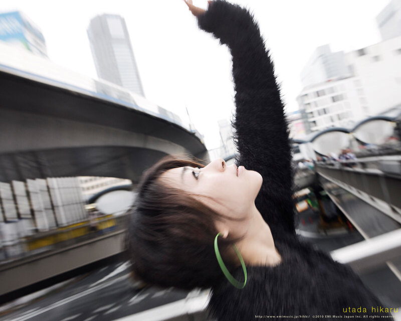 woman with raised arm in city